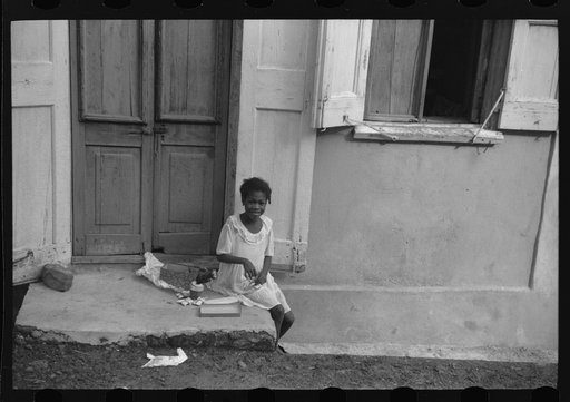 Untitled photo, possibly related to: Little girl playing with her Christmas presents on a side street in Charlotte Amalie, Virgin Islands