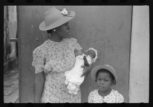 Charlotte Amalie, St. Thomas Island, Virgin Islands. Mother and children waiting on the main street on Sunday