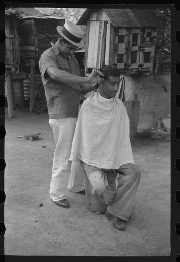 Yabucoa, Puerto Rico. Striker getting a haircut in the mill village near the sugar mill