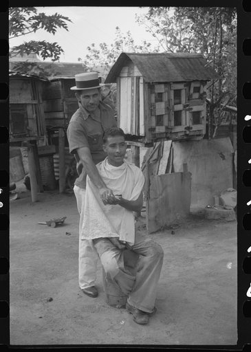 Untitled photo, possibly related to: Yabucoa, Puerto Rico. Striker getting a haircut in the mill village near the sugar mill