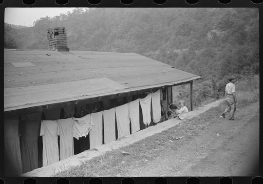 Front of house in abandoned mining community. In foreground is part of main county road. Marine, West Virginia