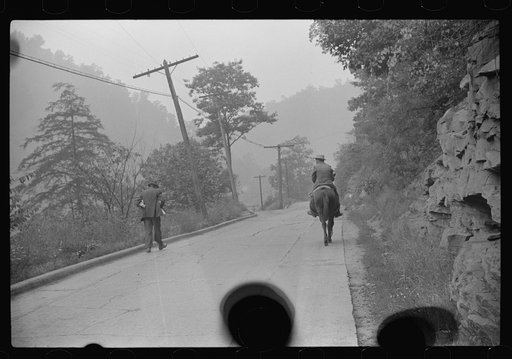 Untitled photo, possibly related to: Old miner on donkey, still quite a common means of transportation, in county road near Mohegan, West Virginia