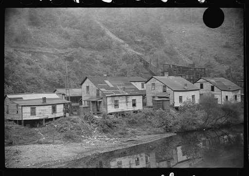 Untitled photo, possibly related to: Houses in abandoned mining town with remains of coal tipple at right, Mohegan, West Virginia