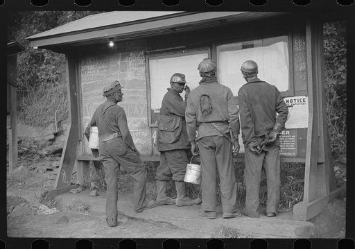 Untitled photo, possibly related to: Miners looking at daily reports, checking the number of tons of slate and coal they loaded during their shift. Also to find out whether or not they work the next day. Caples, West Virginia