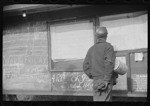 Miner looking at daily reports (company work sheets) checking number of tons of slate he loaded during shift. Also to find out whether or not they work the next day. Caples, West Virginia