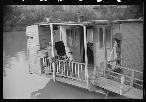 Child on back porch of his home, riverboat house in Charleston, West Virginia