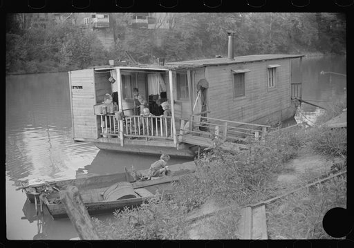 Untitled photo, possibly related to: Child on back porch of his home, riverboat house in Charleston, West Virginia