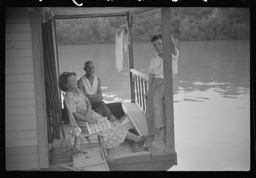 Untitled photo, possibly related to: Child on back porch of his home, riverboat house in Charleston, West Virginia
