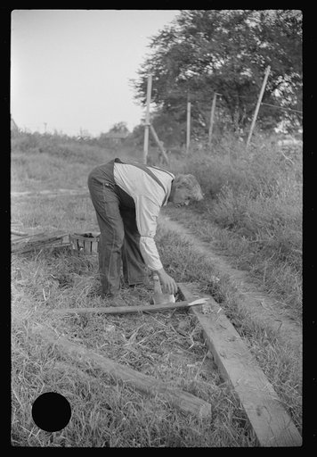 Untitled photo, possibly related to: Man, who lives on houseboat in river chopping wood for stove. Charleston, West Virginia