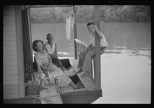 Family on front porch of houseboat on river in Charleston, West Virginia