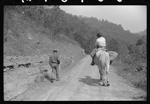 Miner and wife taking home provisions bought at company store, Caples, West Virginia