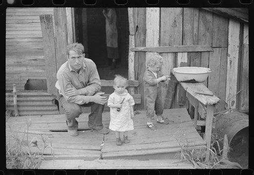Coal miner and two of his children on their back porch. Bertha Hill, West Virginia