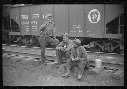 Coal miners waiting for the bus, eating ice cream suckers (popsicles). Pursglove, West Virginia