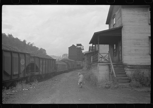 Coal miner's child taking home kerosene for lamps. Company houses, coal tipple in background. Pursglove, Scotts Run, West Virginia