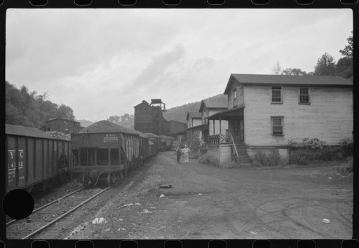 Untitled photo, possibly related to: Coal miner's child taking home kerosene for lamps. Company houses, coal tipple in background. Pursglove, Scotts Run, West Virginia