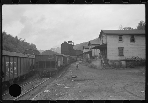 Untitled photo, possibly related to: Coal miner's child taking home kerosene for lamps. Company houses, coal tipple in background. Pursglove, Scotts Run, West Virginia