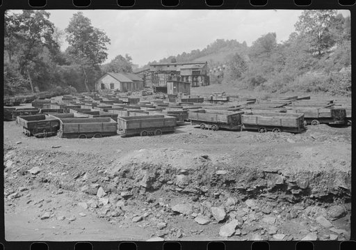 Old coal trucks and tipple in background in abandoned mining town, Jere, West Virginia