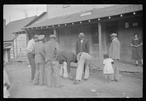 Coal miners shooting craps in front of company store, Chaplin, West Virginia