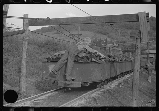 Untitled photo, possibly related to: Coal miner's son swiping coal from coal cars for home use. The "Patch," Chaplin, West Virginia