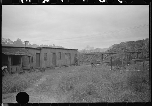 Untitled photo, possibly related to: Section of Rosedale Mining Company. Shanties by the river (burning slag pile to right). These used to be United Mine Workers barracks just thrown up to temporarily house men thrown out of company houses, during strike. Scotts Run, West Virginia