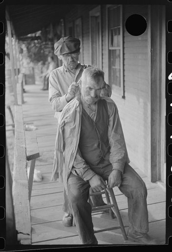 Untitled photo, possibly related to: Miners often give haircuts on front porch. The "Patch," Chaplin, West Virginia