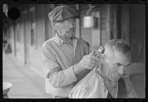 Untitled photo, possibly related to: Miners often give haircuts on front porch. The "Patch," Chaplin, West Virginia