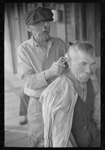 Untitled photo, possibly related to: Miners often give haircuts on front porch. The "Patch," Chaplin, West Virginia