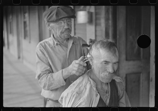 Untitled photo, possibly related to: Miners often give haircuts on front porch. The "Patch," Chaplin, West Virginia