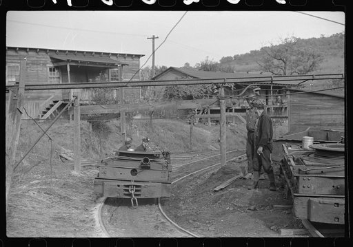 Untitled photo, possibly related to: Coal miner returning from work with pick over shoulder. The "Patch," Chaplin, West Virginia