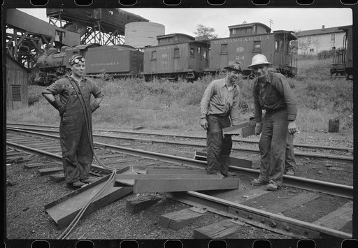 Untitled photo, possibly related to: Workman cutting a steel beam with an acetylane torch near mine tipple and engine house. Scotts Run, West Virginia