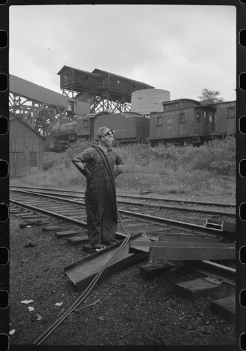 Untitled photo, possibly related to: Workman cutting a steel beam with an acetylane torch near mine tipple and engine house. Scotts Run, West Virginia
