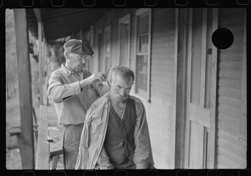 Untitled photo, possibly related to: Miners often give haircuts on front porch. The "Patch," Chaplin, West Virginia