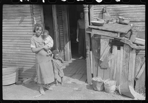 Coal miner's wife and children (note child's legs) in back of their home. Bertha Hill, West Virginia