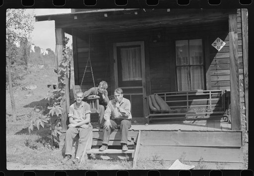 Coal miner and two boys "sittin" around on front porch. Bertha Hill, West Virginia