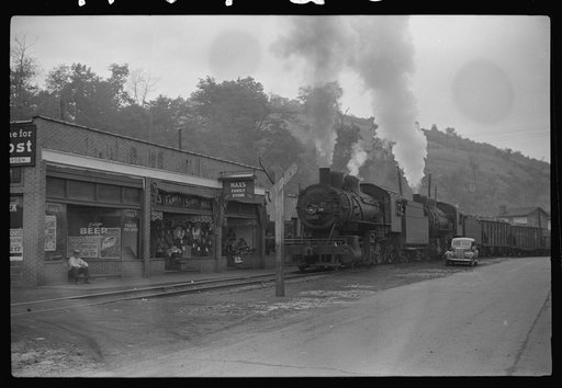 Untitled photo, possibly related to: Train pulls coal through center of town past miners' homes (company houses) several times morning and evening. Osage, West Virginia
