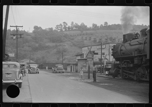 Untitled photo, possibly related to: Train pulls coal through center of town past miners' homes (company houses) several times morning and evening. Osage, West Virginia