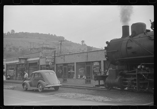 Untitled photo, possibly related to: Train pulls coal through center of town past miners' homes (company houses) several times morning and evening. Osage, West Virginia