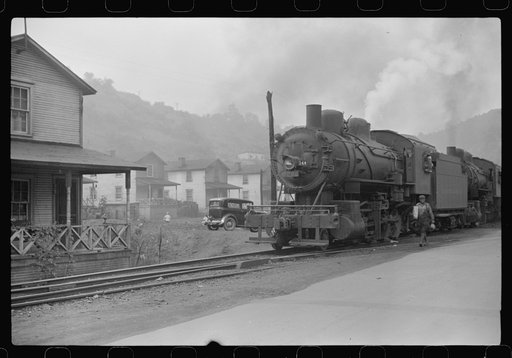 Train pulls coal through center of town past miners' homes (company houses) several times morning and evening. Osage, West Virginia
