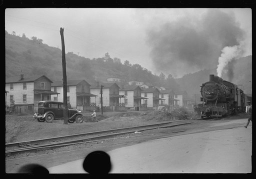 Untitled photo, possibly related to: Train pulls coal through center of town past miners' homes (company houses) several times morning and evening. Osage, West Virginia