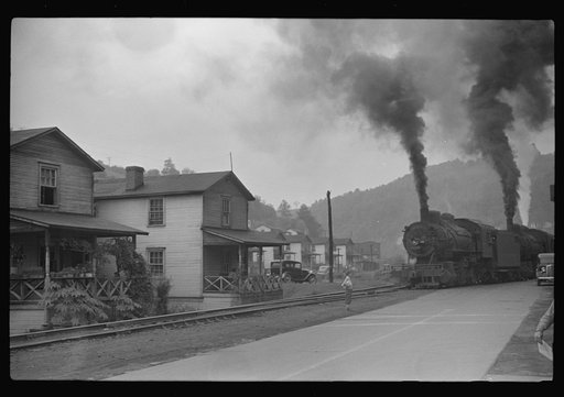Untitled photo, possibly related to: Train pulls coal through center of town past miners' homes (company houses) several times morning and evening. Osage, West Virginia