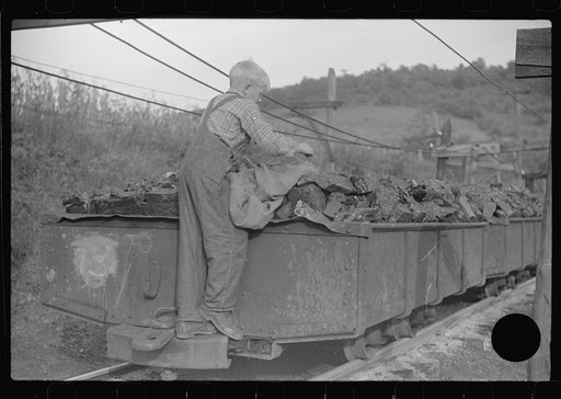 Untitled photo, possibly related to: Coal miner's son swiping coal from coal cars for home use. The "Patch," Chaplin, West Virginia