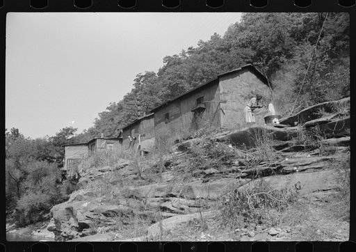 Negro woman washing clothes outside of shacks along the river. On highway between Charleston and Gauley Bridge, West Virginia