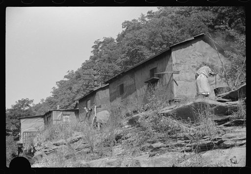 Untitled photo, possibly related to: Negro woman washing clothes outside of shacks along the river. On highway between Charleston and Gauley Bridge, West Virginia