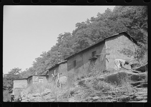 Untitled photo, possibly related to: Negro woman washing clothes outside of shacks along the river. On highway between Charleston and Gauley Bridge, West Virginia