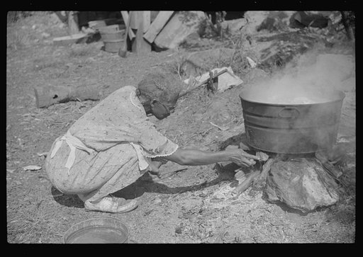 Negro woman washing clothes outside of shacks along the river, on highway between Charleston and Gauley Bridge, West Virginia