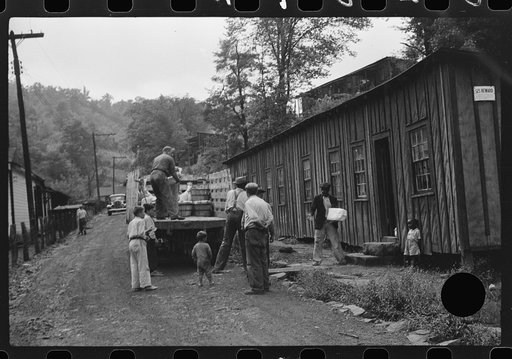 Untitled photo, possibly related to: The relief truck brings food supplies to abandoned mining town, Jere, West Virginia. The shack on right is used as community house for prayer and church meetings, union and water company meetings, etc. Is represented by many people whose homes are so much worse t