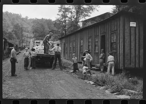 Untitled photo, possibly related to: The relief truck brings food supplies to abandoned mining town, Jere, West Virginia. The shack on right is used as community house for prayer and church meetings, union and water company meetings, etc. Is represented by many people whose homes are so much worse t