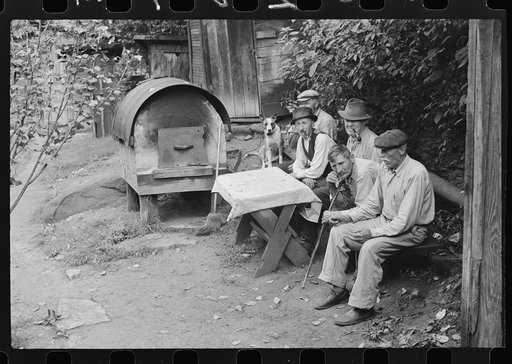 Bohemian miners (coal loaders) unemployed since mechanization of mines. Jere, West Virginia. They live together in one house with a woman housekeeper. All on relief. Spend most of their time fighting about politics. Call their dog "Hitler" because he's so mean and nasty. To the left is an outdoor ov