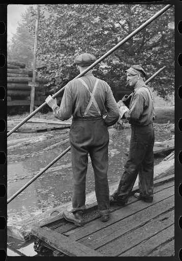 Men spiking logs to go up ramp into sawmill. It was working only halftime and was even slower in winter. "It's kinder hard them times. Concrete and steel's taking the place of lumber nowadays." Erwin, West Virginia