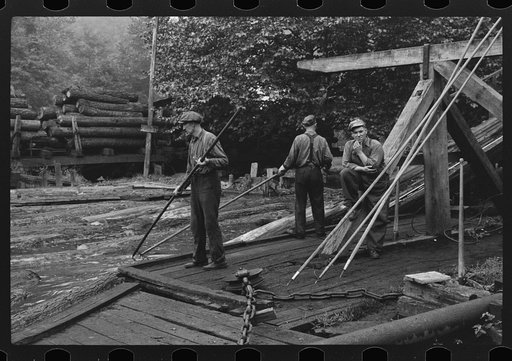 Men spiking logs to go up ramp into sawmill. It was working only halftime and was even slower in winter.  "It's kinder hard them times. Concrete and steel's taking the place of lumber nowadays. Erwin, West Virginia